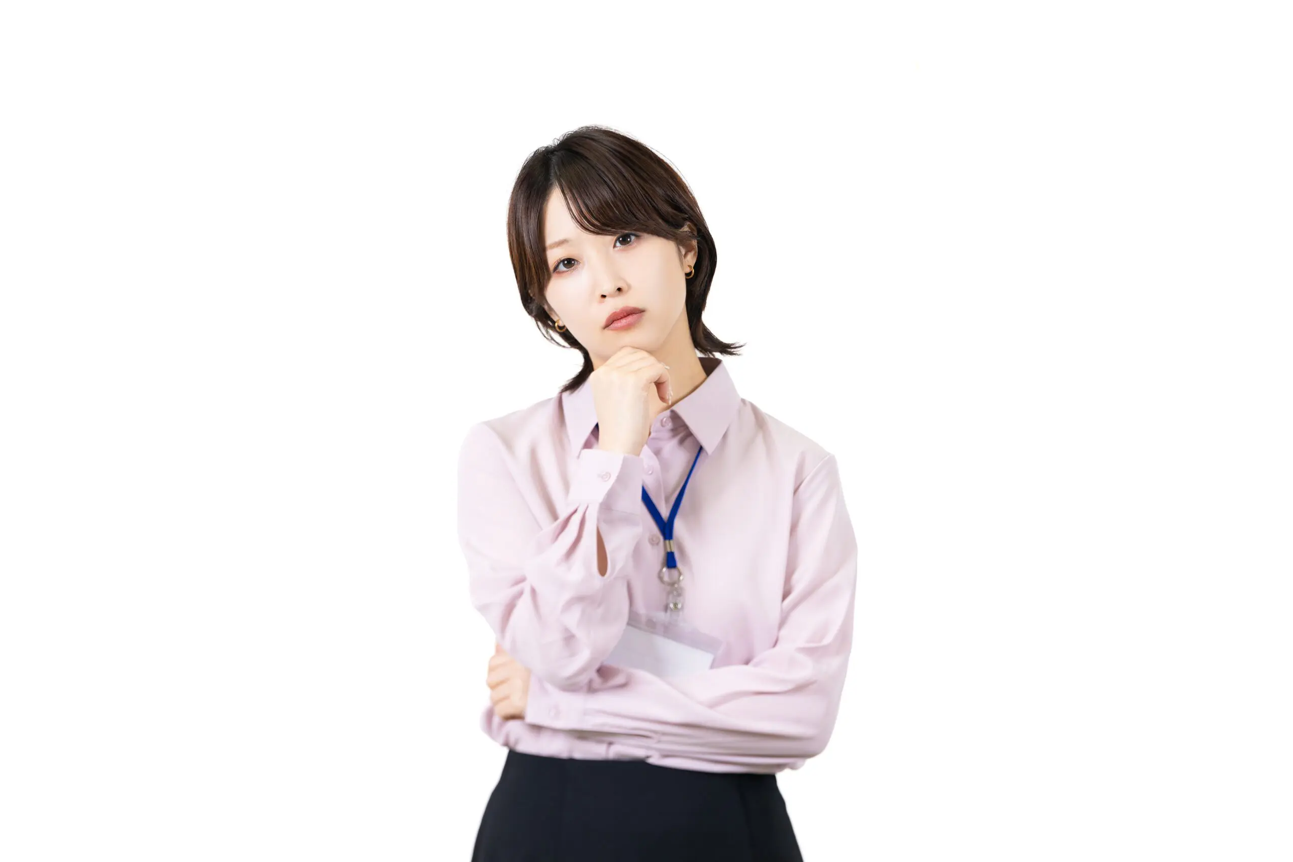 淡いピンクのシャツと濃い色のズボンをはいた人物が、無地の白い背景を背景に、顎に手を当て、思慮深い表情で次のキャリア (転職) について考えている。オンライン プログラミング スクールのストラップから ID バッジが首にぶら下がっており、新たな始まりと不安の緩和を象徴している。.