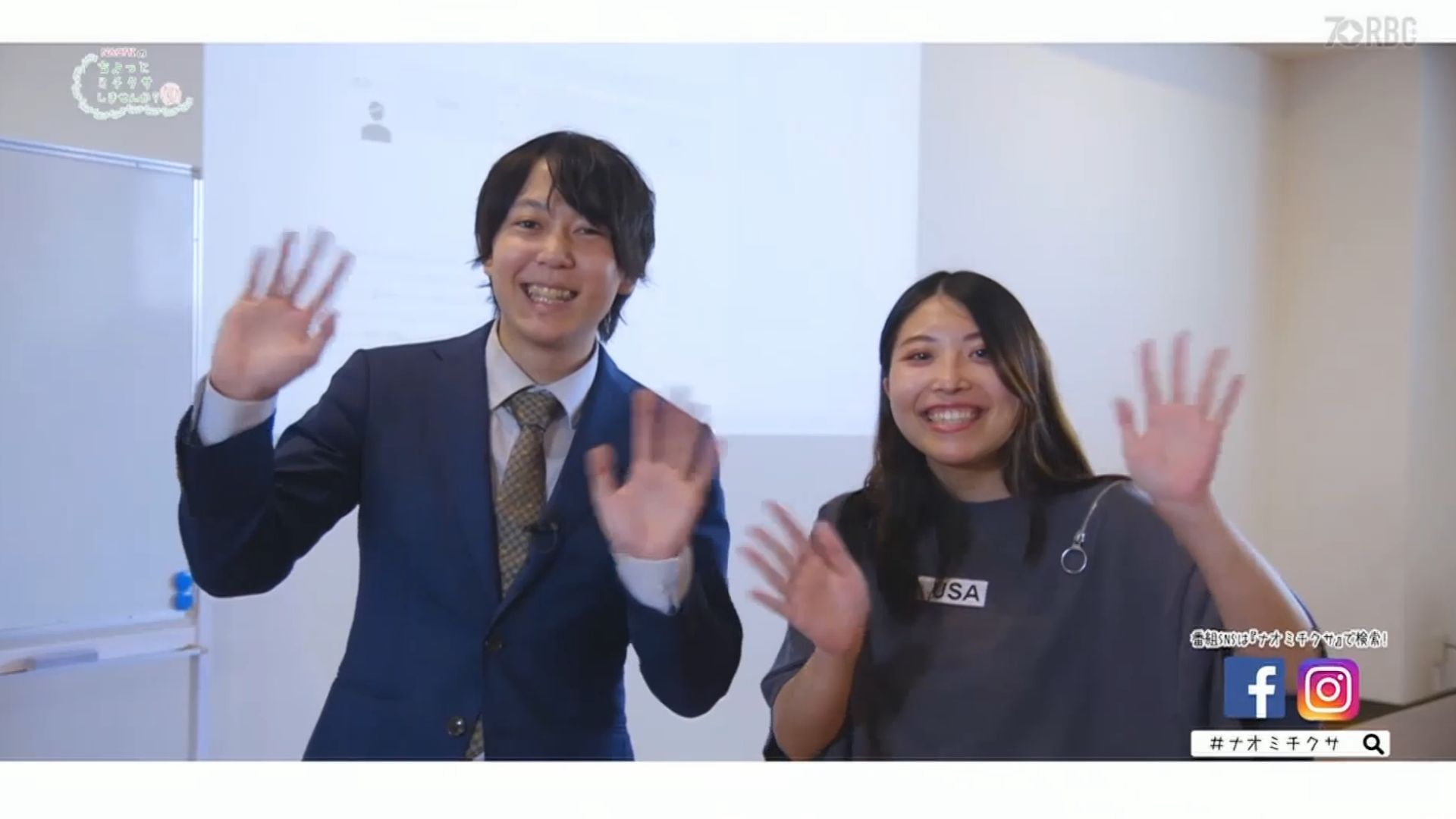 2 人が笑顔でカメラに向かって手を振っています。左側の人物はスーツを着ており、右側の人物はカジュアルな服装をしています。右下隅にはソーシャル メディアのアイコンと RBC 放送が表示されており、彼らの楽しいひとときに現代的なつながりを感じさせます。.